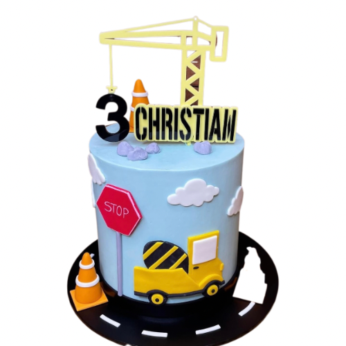 A construction-themed birthday cake with yellow and black cake toppers, including a crane, number, and a name charm.