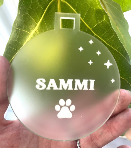 A personalised pet Christmas tree ornament with the name 'Sammi' printed on it, featuring a star and paw print design.