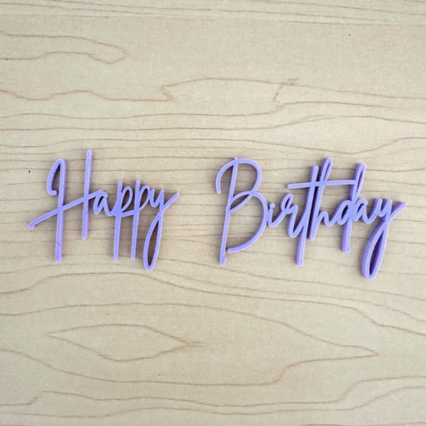 Purple 'Happy Birthday' decoration on a wooden surface