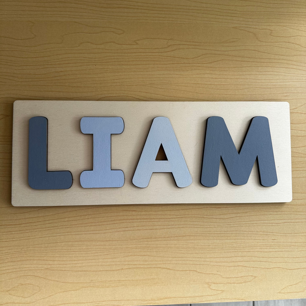 Wooden nameplate with the name 'LIAM' on a wooden surface