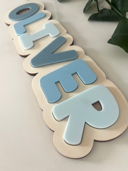 Wooden letters spelling 'OLIVER' on a light background