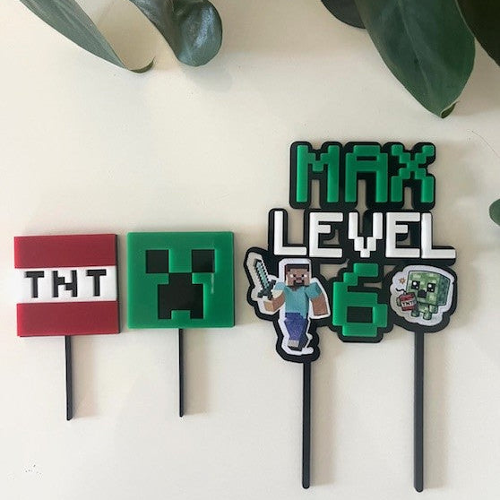 Set of Minecraft-themed cake toppers on a white background with green leaves.