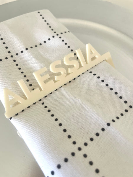 Decorative nameplate with 'ALESSIA' on a white fabric background