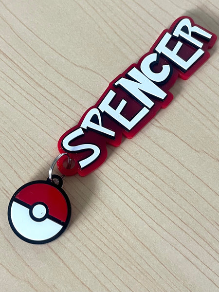 Keychain with 'SPENCER' text and a Pokémon Ball design on a beige background