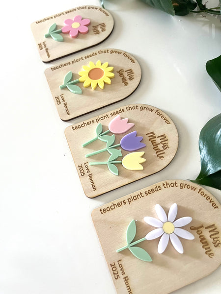 Set of wooden name tags with floral designs on a white surface.